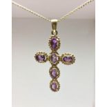 A 9ct yellow gold and amethyst set cross pendant, inset with six oval cut amethysts, the clasp