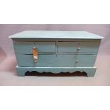A blue painted pine low chest of drawers, having two short over two long drawers, raised on shaped