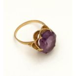 A ladies 9ct yellow gold and amethyst set ring, the oval cut amethyst in pierced 9ct gold mount,