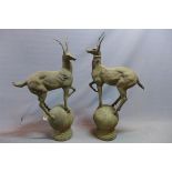 A near pair of cast iron stags, raised on spherical bases, H.100cm (tallest)