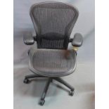 A Herman Miller swivel office chair, with adjustable seat and arm rests, raised on castors