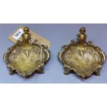 A pair of brass dishes, decorated in the Rococo taste with cherubs and C-scrolls, W.12cm