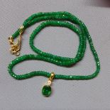 An emerald beaded necklace with oval cut emerald pendant in 18ct yellow gold mount, having 18ct