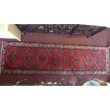 A fine Northwest Persian Rudbar runner with repeating stylised diamond medallion on a rouge field,