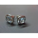 A pair of 18ct white gold, aquamarine and diamond set earrings, having central cushion cut