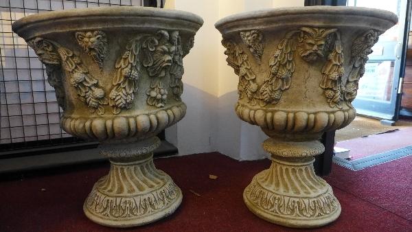 A pair of reconstituted stone urns, decorated with lion masks and swags of flowers, H.58cm