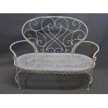 A white painted wrought iron two seater garden bench