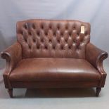 A Contemporary Chesterfield style sofa, with brown leather button back upholstery, raised on