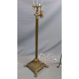 An early 20th century brass Corinthian column standard lamp, raised on square base and paw feet