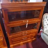 A Contemporary pine cabinet with two glazed pull up slide in doors over two drawers, raised on