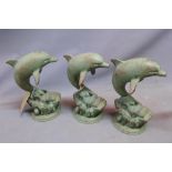 A set of three cast iron models of dolphins