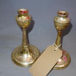 A pair of filled silver candlesticks, indistinctly hallmarked London