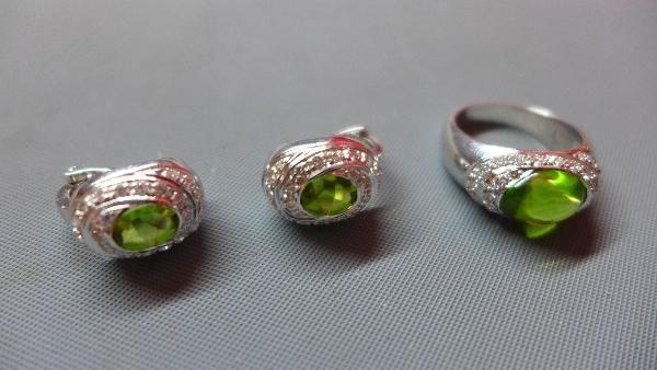 An 18ct white gold, peridot and diamond set ring, having a central oval cut peridot within pave