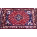 A fine Southwest Persian Qashqai carpet with a central diamond medallion on a rouge filled within