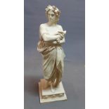 A reconstituted marble figure of a Classical figure in flowing robes and wearing a wreath, on