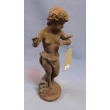 A cast iron putto holding a butterfly, on circular base, H.51cm
