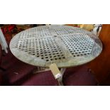 A circular weathered teak garden table