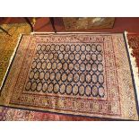 A Bokhara style rug, with elephant pad motifs, on a blue ground, contained by geometric border,