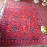 A Pakistani carpet, with geometric motifs, on a red ground, contained by geometric borders, 196 x