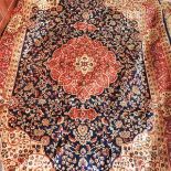 A Kashan style carpet, with central floral medallion, on a blue ground, contained by floral