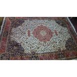 A Kashan style carpet, with central floral medallion, on a beige ground, contained by floral