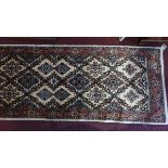A fine Northwest Persian Rudbar runner with repeating stylised ivory floral motifs guarded by a