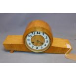 An oak veneered Art Deco style bracket clock, the white chapter ring with Arabic numerals, on