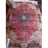 A Kashan style carpet, with central floral medallion, on a red ground, contained by floral border,