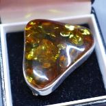A Baltic amber brooch in a white metal mount, stamped 925, and stamped to pin, from the region of