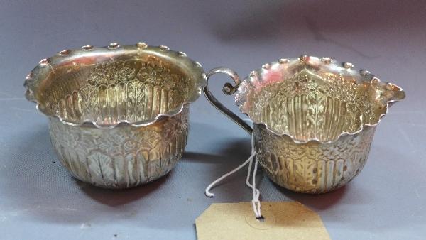 A Victorian silver bowl and matching milk jug, having gadrooned decoration and embossed with