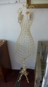 An early 20th century wire work dress makers dummy, raised on wrought iron base