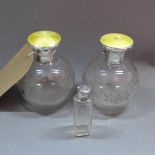 A pair of acid etched scent bottles, with silver a guilloche enamel tops, together with one other