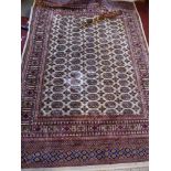 A Bokhara style carpet, with elephant pad motifs, on a beige ground, contained by geometric borders,