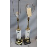 A pair of gilt metal and porcelain table lamps, raised on ebonized bases