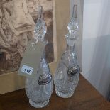 A pair of tall cut glass decanters with stoppers and silver plated wine and brandy labels. H.40cm