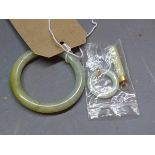 A jade ladies bangle along with two jade pendants, one being of oval form the other cylindrical,