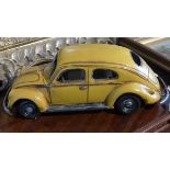 A yellow metal model of a volkswagen beetle. 33cm long