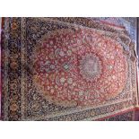 A Kashan style carpet, with central floral medallion, on a red ground, contained by floral border,