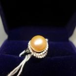 A white metal, pearl and diamond inset ring, indistinctly stamped to shank