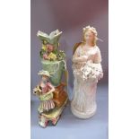 A continental bisque figure of a lady carrying fruit and flowers, together with another figure of