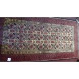 A fine North East Persian Meshad Belouch rug with repeating stylised petal motifs on a camel field