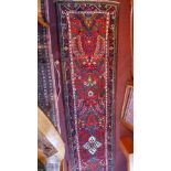 A fine Central Persian Sarouk runner with repeating stylised floral motifs on a rouge field