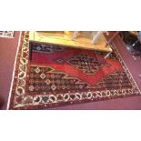 A fine North West Persian Mazlaghan rug with central diamond medallion on a rouge field within