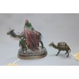 A cold cast bronze study of man on a camel holding a carpet with attendant, signed C Kauba, on