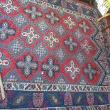 A Persian carpet with multi-coloured medallions on a red ground, with multi-coloured geometric