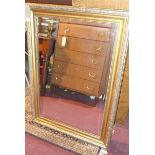 A gilt wall mirror with bevelled glass plate and C-scroll decorated frame, H.108 W.77cm