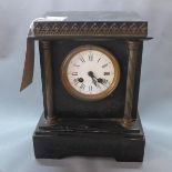 A black slate mantel clock, the dial with Roman and Arabic numerals, the case of archectural form