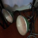 A pair of green industrial lights with wall attachments