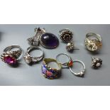 A collection of silver and white metal rings, to include a silver and garnet inset ring in the