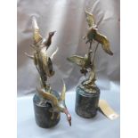 A near pair of cast bronze studies of ducks preparing to fly from a branch, on marble bases, both